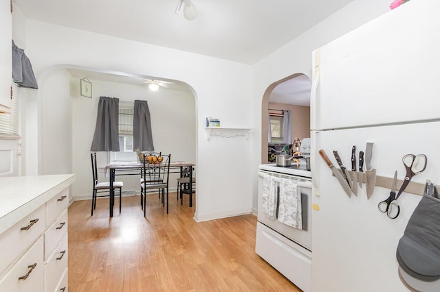 1814 E Washington St, Joliet, IL 60433 - kitchen with white appliances, arched walkways, light countertops, light wood-style flooring, and ceiling fan