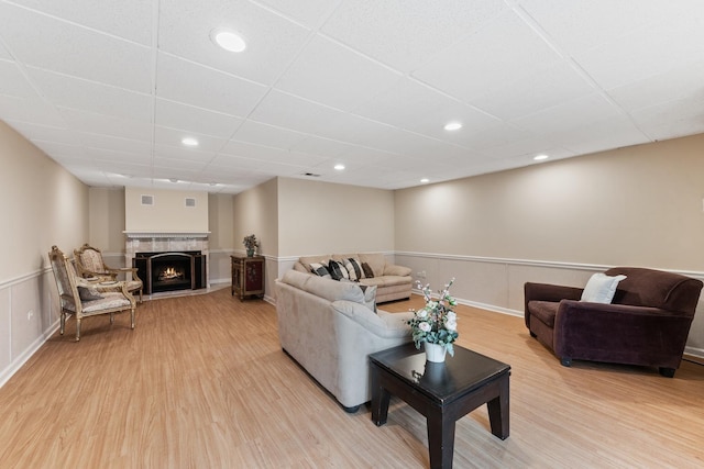 2S570 Patrick Henry Sq Unit 119, Oak Brook, IL 60523 - living room with a paneled ceiling, light wood-style flooring, a warm lit fireplace, and recessed lighting