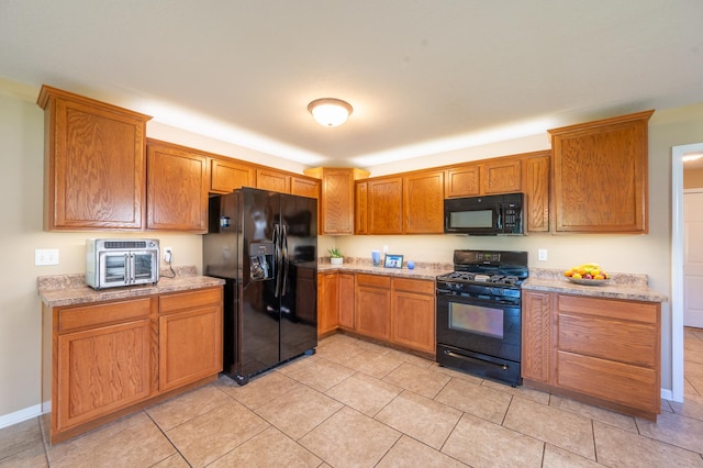 1715 W River St Unit 1715, Dixon, IL 61021 - kitchen with black appliances, brown cabinetry, light tile patterned floors, and light stone counters