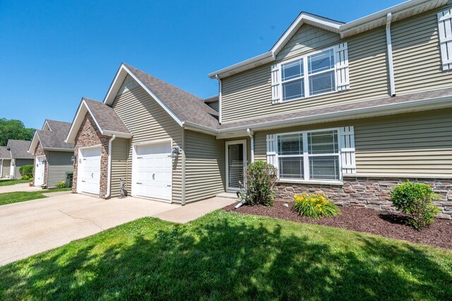 1715 W River St Unit 1715, Dixon, IL 61021 - view of front of home with an attached garage, concrete driveway, a front yard, roof with shingles, and stone siding