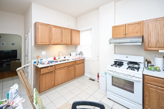 2834 S Union Ave, Chicago, IL 60616 - kitchen featuring gas range gas stove, under cabinet range hood, light countertops, and light tile patterned floors