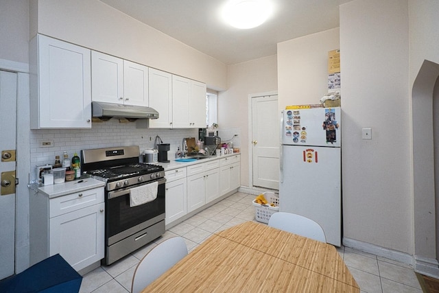 2834 S Union Ave, Chicago, IL 60616 - kitchen featuring gas stove, freestanding refrigerator, under cabinet range hood, backsplash, and white cabinets
