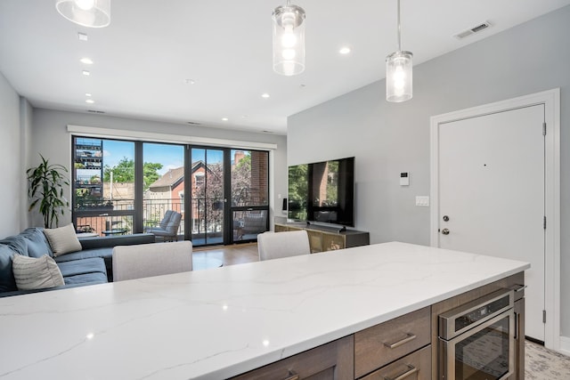 1011 N Winchester Ave Unit 2, Chicago, IL 60622 - kitchen with open floor plan, light stone counters, decorative light fixtures, recessed lighting, and stainless steel microwave