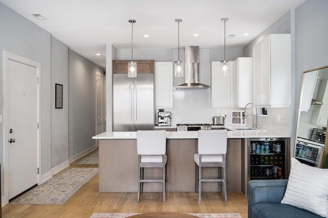 1011 N Winchester Ave Unit 2, Chicago, IL 60622 - kitchen with built in refrigerator, wall chimney exhaust hood, light wood-type flooring, light countertops, and recessed lighting