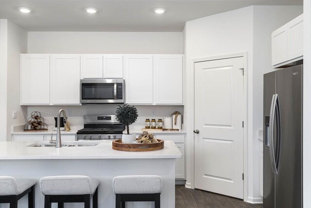 2281 Redwood Trl, Wonder Lake, IL 60097 - kitchen with stainless steel appliances, a kitchen breakfast bar, white cabinets, dark wood-type flooring, and recessed lighting