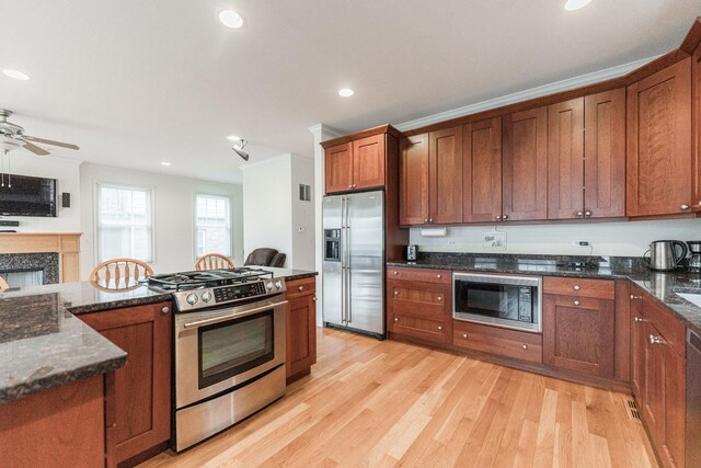 3723 N Nordica Ave, Chicago, IL 60634 - kitchen featuring appliances with stainless steel finishes, light wood-style floors, a premium fireplace, ceiling fan, and brown cabinetry