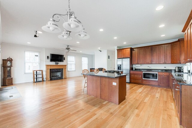 3723 N Nordica Ave, Chicago, IL 60634 - kitchen featuring stainless steel appliances, recessed lighting, a ceiling fan, a breakfast bar area, and a fireplace