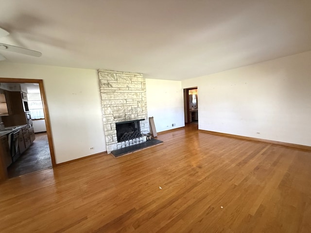 419 S Chase Ave, Lombard, IL 60148 - unfurnished living room featuring a ceiling fan, a stone fireplace, and wood finished floors