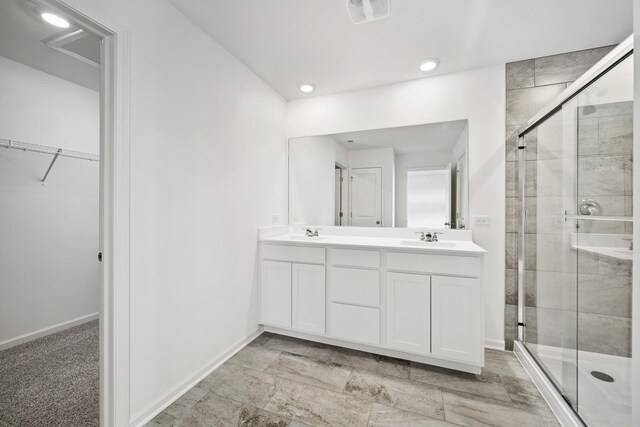 15063 W Oxford Ln, Manhattan, IL 60442 - bathroom featuring a stall shower, double vanity, a walk in closet, and recessed lighting