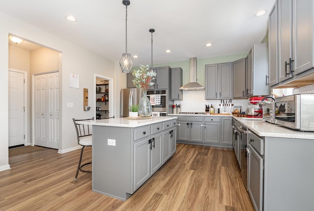26550 W Old Stage Ln, Channahon, IL 60410 - kitchen with gray cabinetry, wall chimney exhaust hood, light wood-style flooring, backsplash, and recessed lighting