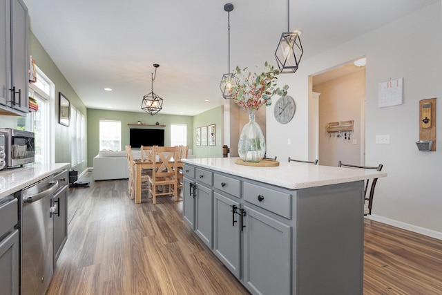 26550 W Old Stage Ln, Channahon, IL 60410 - kitchen with gray cabinetry, stainless steel dishwasher, dark wood finished floors, open floor plan, and hanging light fixtures