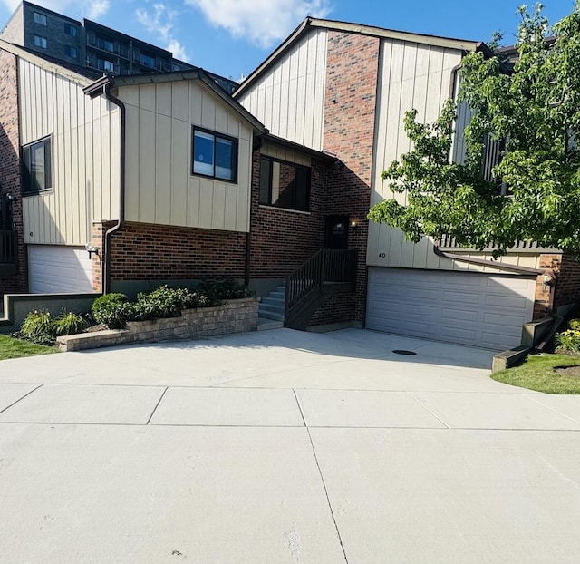 40 Portwine Rd, Willowbrook, IL 60527 - view of front of home featuring board and batten siding, a garage, concrete driveway, and brick siding