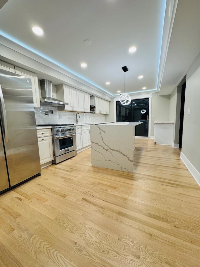 40 Portwine Rd, Willowbrook, IL 60527 - kitchen with wall chimney exhaust hood, appliances with stainless steel finishes, light wood-style flooring, white cabinetry, and tasteful backsplash