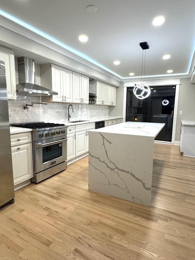 40 Portwine Rd, Willowbrook, IL 60527 - kitchen featuring wall chimney exhaust hood, appliances with stainless steel finishes, a kitchen island, tasteful backsplash, and light wood-style flooring