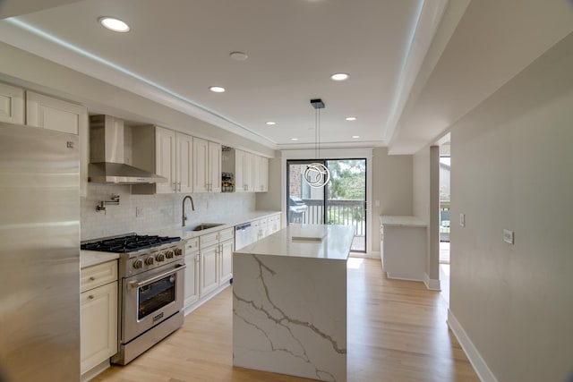 40 Portwine Rd, Willowbrook, IL 60527 - kitchen with wall chimney range hood, appliances with stainless steel finishes, light wood-type flooring, decorative backsplash, and light stone countertops