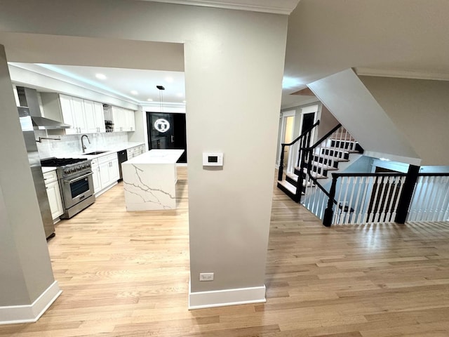 40 Portwine Rd, Willowbrook, IL 60527 - kitchen with high end stove, black dishwasher, light wood-style floors, wall chimney exhaust hood, and ornamental molding