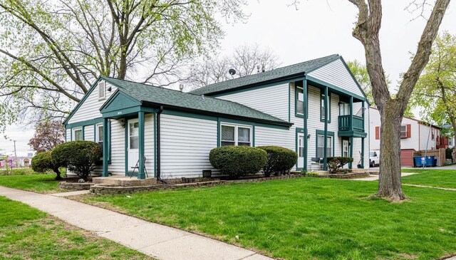 509 Darlene Ln Unit A, Glendale Heights, IL 60139 - view of front of house with a balcony, roof with shingles, and a front lawn