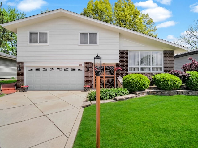 18 E 155th Pl, South Holland, IL 60473 - split level home featuring brick siding, a front lawn, a garage, and driveway