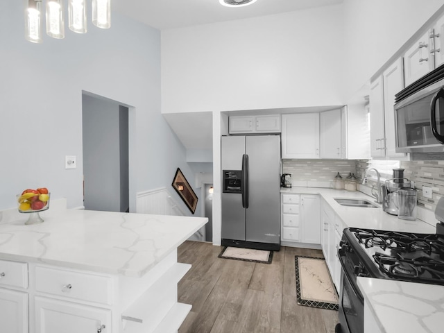 18 E 155th Pl, South Holland, IL 60473 - kitchen featuring stainless steel appliances, light wood finished floors, a towering ceiling, tasteful backsplash, and light stone countertops