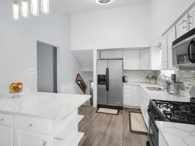 18 E 155th Pl, South Holland, IL 60473 - kitchen with appliances with stainless steel finishes, light wood-type flooring, a towering ceiling, decorative backsplash, and light stone countertops