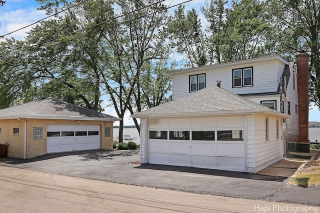 36 S Pistakee Lake Rd, Fox Lake, IL 60020 - view of front of home featuring a garage, an outdoor structure, a chimney, and a shingled roof