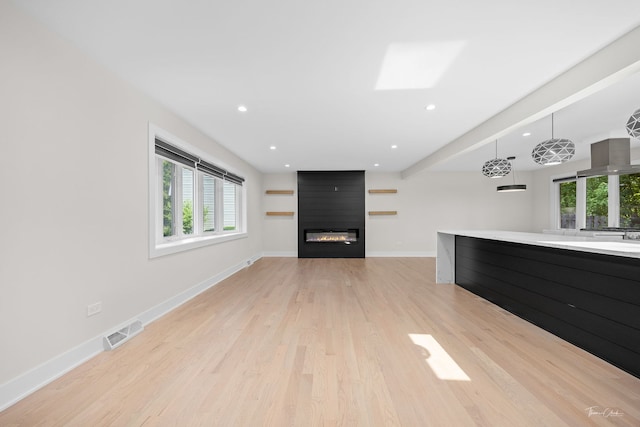13741 S 85th Ave, Orland Park, IL 60462 - unfurnished living room featuring plenty of natural light, light wood-style floors, a fireplace, recessed lighting, and a skylight