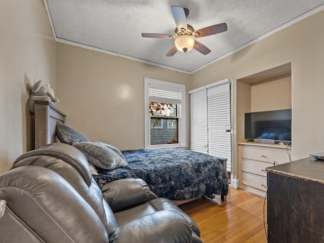 2529 Scoville Ave, Berwyn, IL 60402 - bedroom featuring light wood-style flooring, crown molding, a textured ceiling, and a ceiling fan