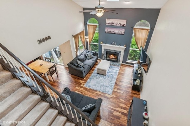 1063 Ridgefield Cir, Carol Stream, IL 60188 - living area with ceiling fan, a high ceiling, stairs, wood finished floors, and a premium fireplace