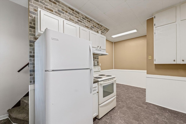 543 E Orleans St, Paxton, IL 60957 - kitchen featuring white appliances, under cabinet range hood, white cabinets, and a wainscoted wall