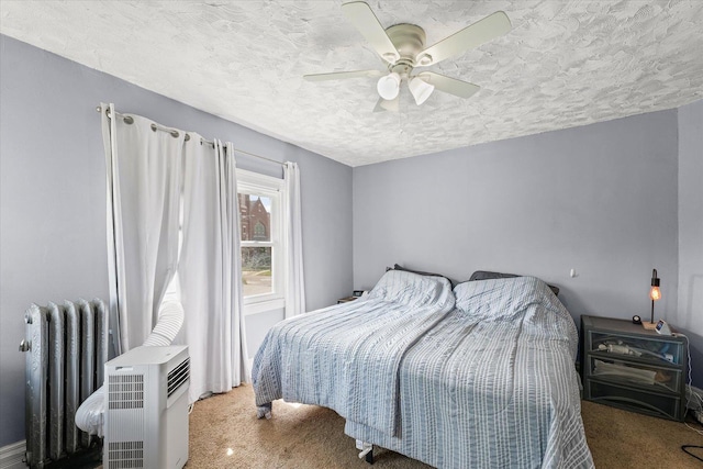 543 E Orleans St, Paxton, IL 60957 - bedroom featuring radiator heating unit, carpet flooring, a textured ceiling, and a ceiling fan