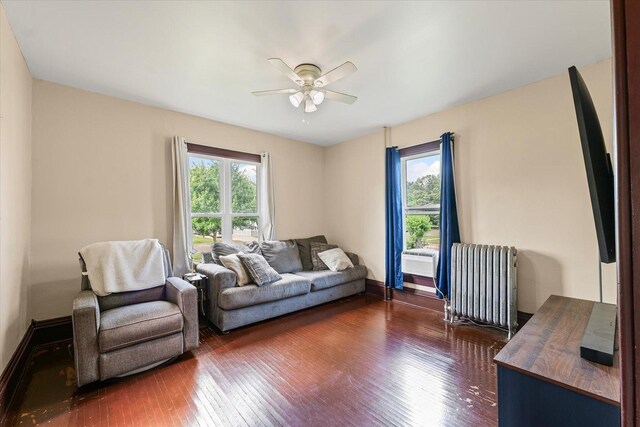 543 E Orleans St, Paxton, IL 60957 - living area with radiator heating unit, dark wood-style floors, healthy amount of natural light, and ceiling fan