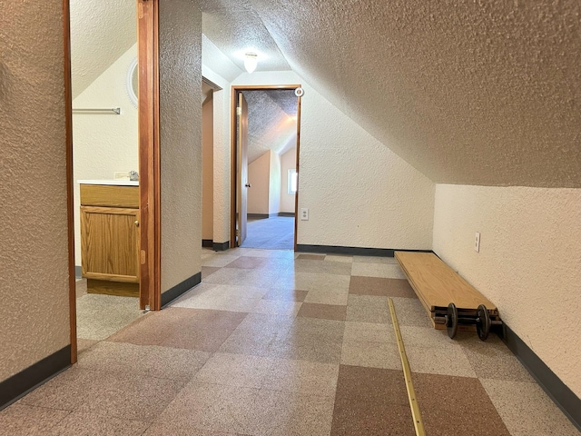 5608 S Spaulding Ave, Chicago, IL 60629 - hallway featuring a textured wall, a textured ceiling, lofted ceiling, and light floors