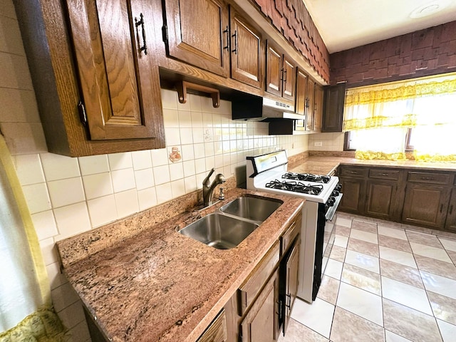 5608 S Spaulding Ave, Chicago, IL 60629 - kitchen with range with gas cooktop, under cabinet range hood, light stone counters, and backsplash