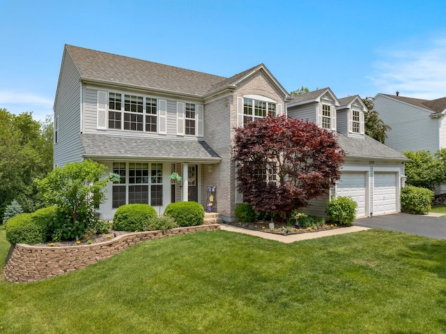 514 Abbeywood Dr, Cary, IL 60013 - traditional-style home featuring asphalt driveway, a front lawn, a garage, and roof with shingles