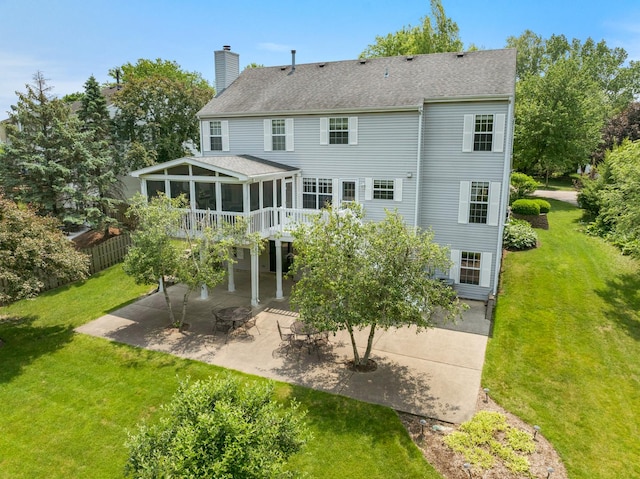 514 Abbeywood Dr, Cary, IL 60013 - rear view of house featuring a sunroom, a patio, a chimney, a lawn, and a shingled roof