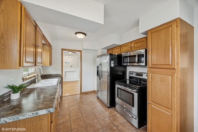 1627 Downing Ave, Westchester, IL 60154 - kitchen with stainless steel appliances, dark countertops, tile patterned floors, ceiling fan, and brown cabinetry