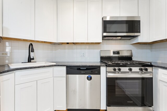 3200 N Lake Shore Dr Unit 302, Chicago, IL 60657 - kitchen with appliances with stainless steel finishes, backsplash, white cabinetry, and dark stone countertops