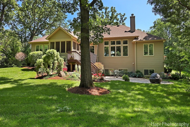 9516 Thousand Oaks Dr, Spring Grove, IL 60081 - back of house featuring a patio, a sunroom, a chimney, stairway, and a yard