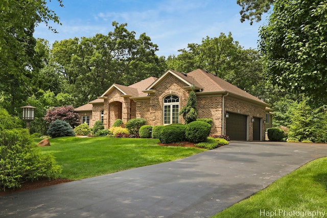 9516 Thousand Oaks Dr, Spring Grove, IL 60081 - view of front facade with brick siding, driveway, a garage, a front yard, and roof with shingles