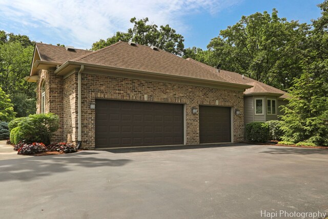 9516 Thousand Oaks Dr, Spring Grove, IL 60081 - view of side of property featuring brick siding, an attached garage, driveway, and a shingled roof