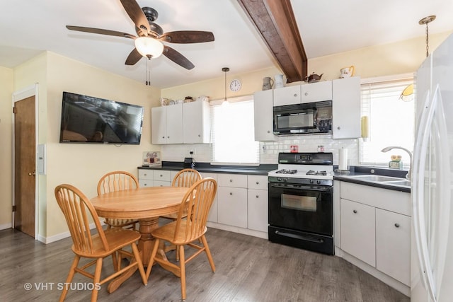 1429 N May St, Joliet, IL 60435 - kitchen featuring black microwave, range with gas stovetop, dark countertops, dark wood-type flooring, and backsplash