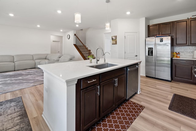 153 N Bend Way, Elgin, IL 60124 - kitchen featuring appliances with stainless steel finishes, light countertops, dark brown cabinetry, light wood-style flooring, and hanging light fixtures