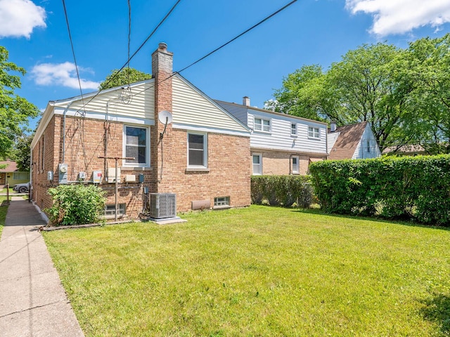 2408 Nathaniel Pl, Evanston, IL 60202 - back of property with a chimney, a lawn, and brick siding