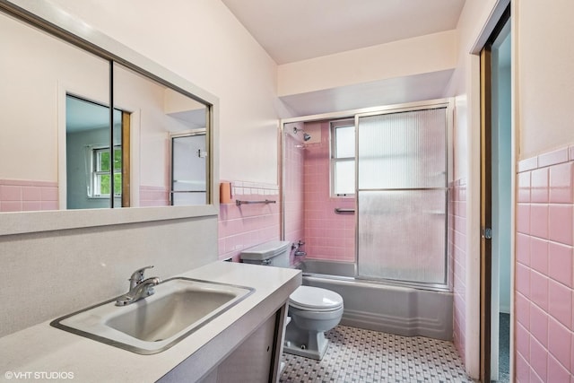 217 Heather Ln, Wilmette, IL 60091 - full bathroom featuring tile walls, plenty of natural light, a wainscoted wall, vanity, and enclosed tub / shower combo