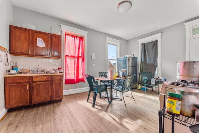 2330 S Homan Ave, Chicago, IL 60623 - kitchen with freestanding refrigerator, light wood-style floors, light countertops, and brown cabinets