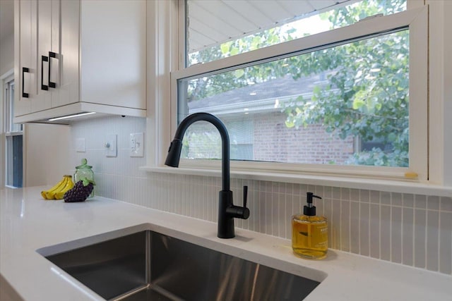 7418 Kildare Ave, Skokie, IL 60076 - kitchen view of backsplash, white cabinetry, and light stone counters
