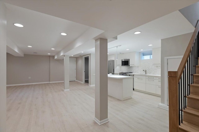 7418 Kildare Ave, Skokie, IL 60076 - kitchen with light wood-style floors, open floor plan, light countertops, white cabinets, and tasteful backsplash