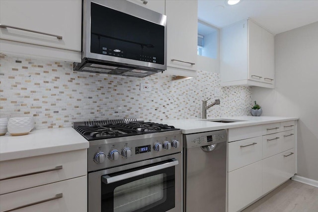7418 Kildare Ave, Skokie, IL 60076 - kitchen featuring appliances with stainless steel finishes, white cabinets, light countertops, and decorative backsplash
