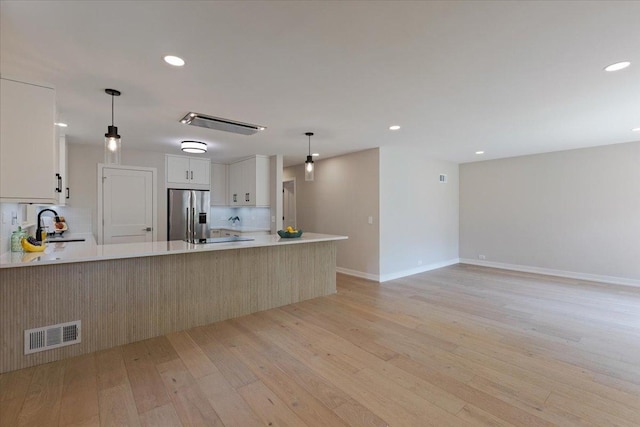 7418 Kildare Ave, Skokie, IL 60076 - kitchen with stainless steel fridge, light wood finished floors, light countertops, a peninsula, and recessed lighting