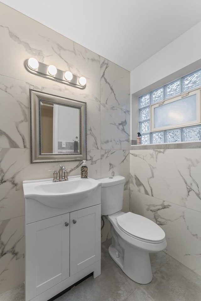 3257 N Nottingham Ave, Chicago, IL 60634 - bathroom featuring tile walls, vanity, stone wall, and marble finish floors